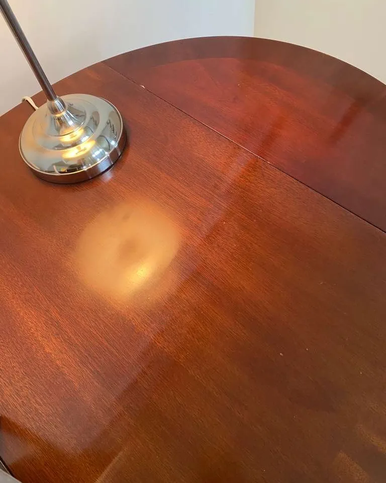 The same table polished, reflecting the lamp above it.