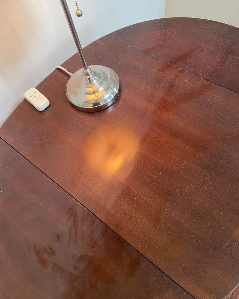 A wooden dining table dulled by marks and smears.