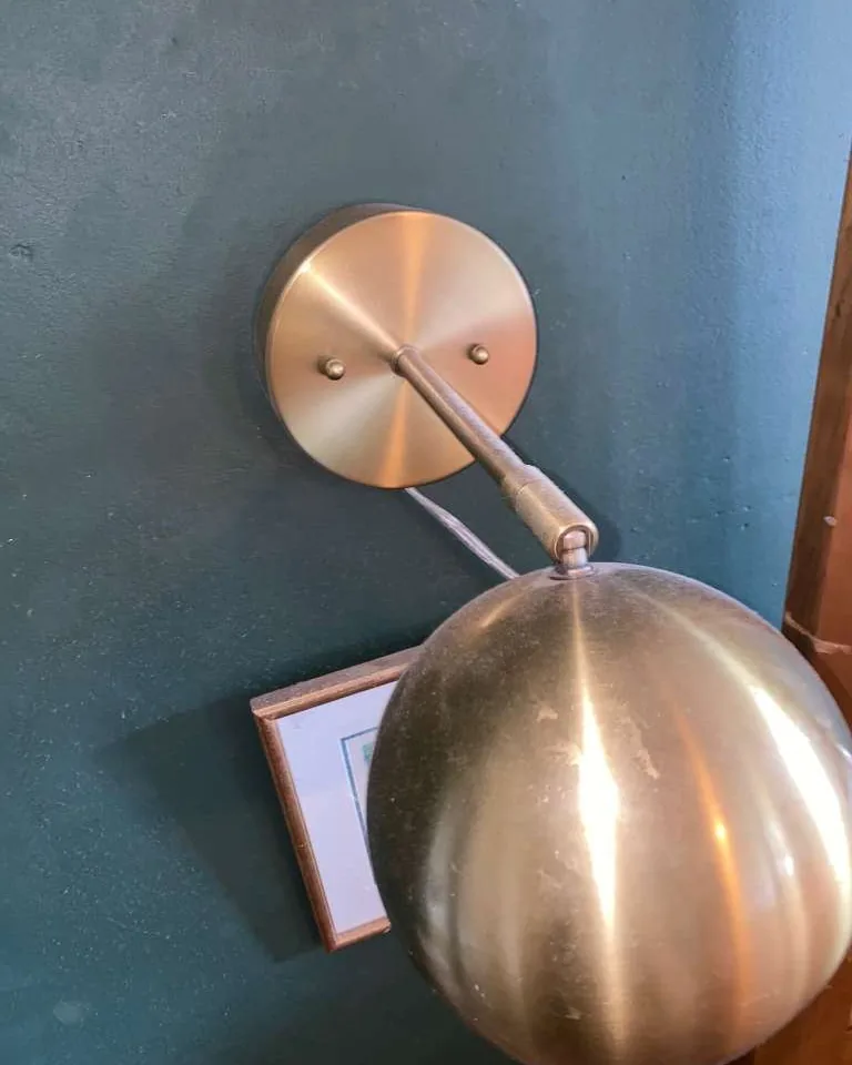 A brass wall sconce dulled with dust and fingerprints.