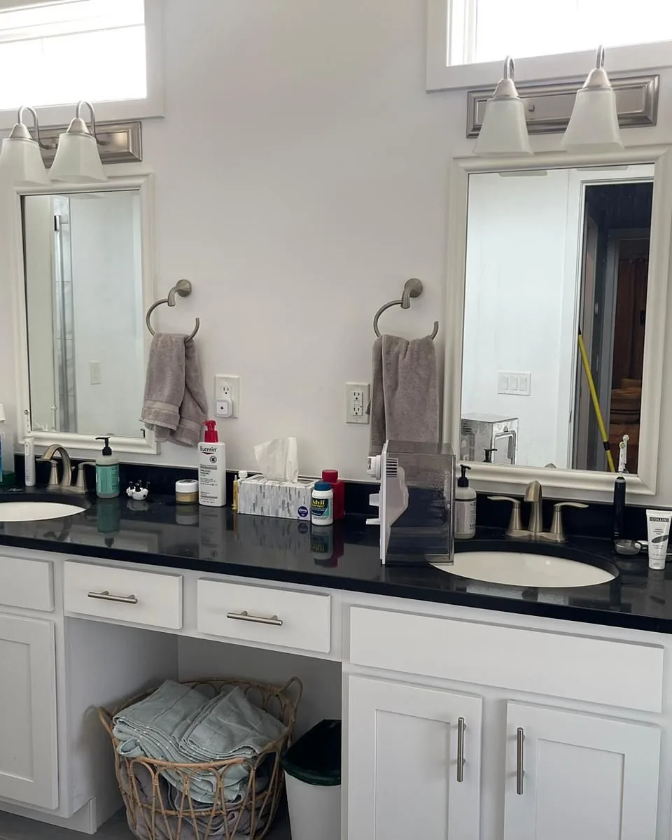 A double bathroom vanity crowded with bottles and used towels.